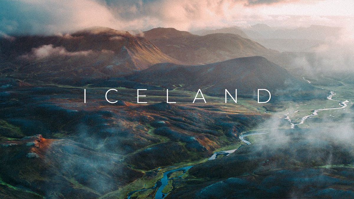 Ferðafólk horfir yfir jökulblátt vatn, svartan sand og mosagrænt hraun á Íslandi